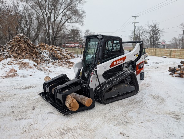 Bobcat track loader with log grapple in snow